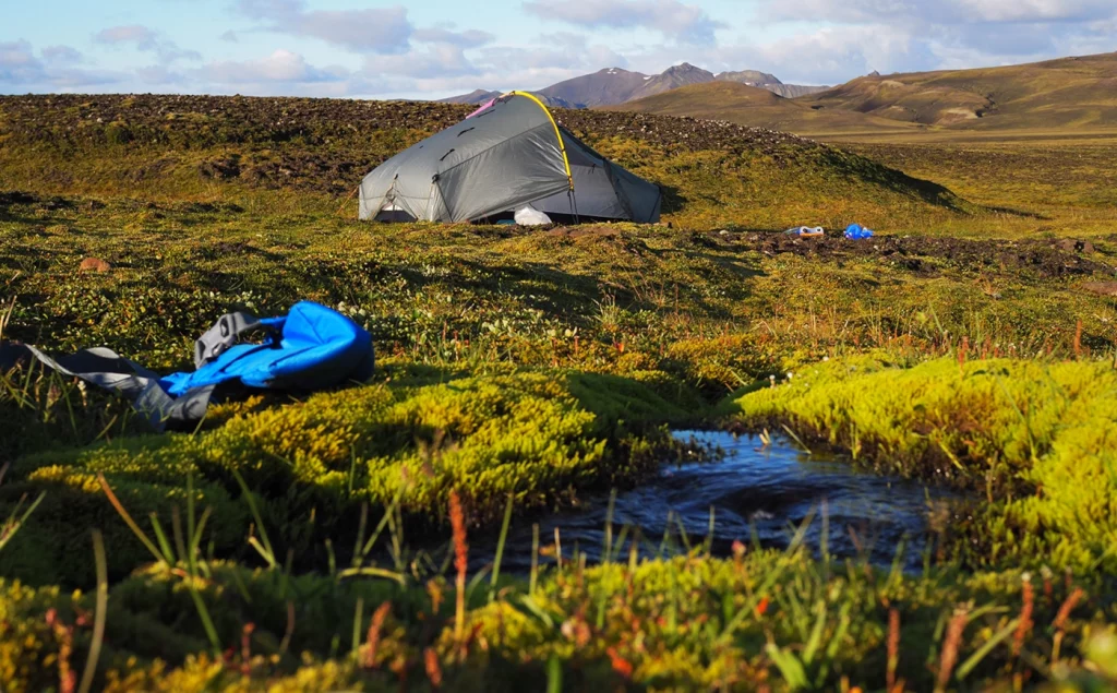 Zelt an einem Bach in Island