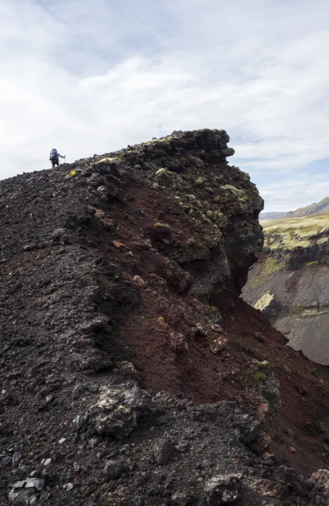 Person steht auf einem hohen grauen Steinberg