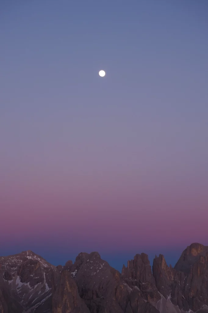 Der Mond bei Sonnenuntergang über einer Bergkette