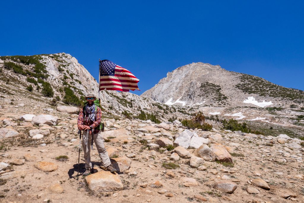 Ein Wanderer hat eine riesige USA-Flagge an seinem Rucksack befestigt